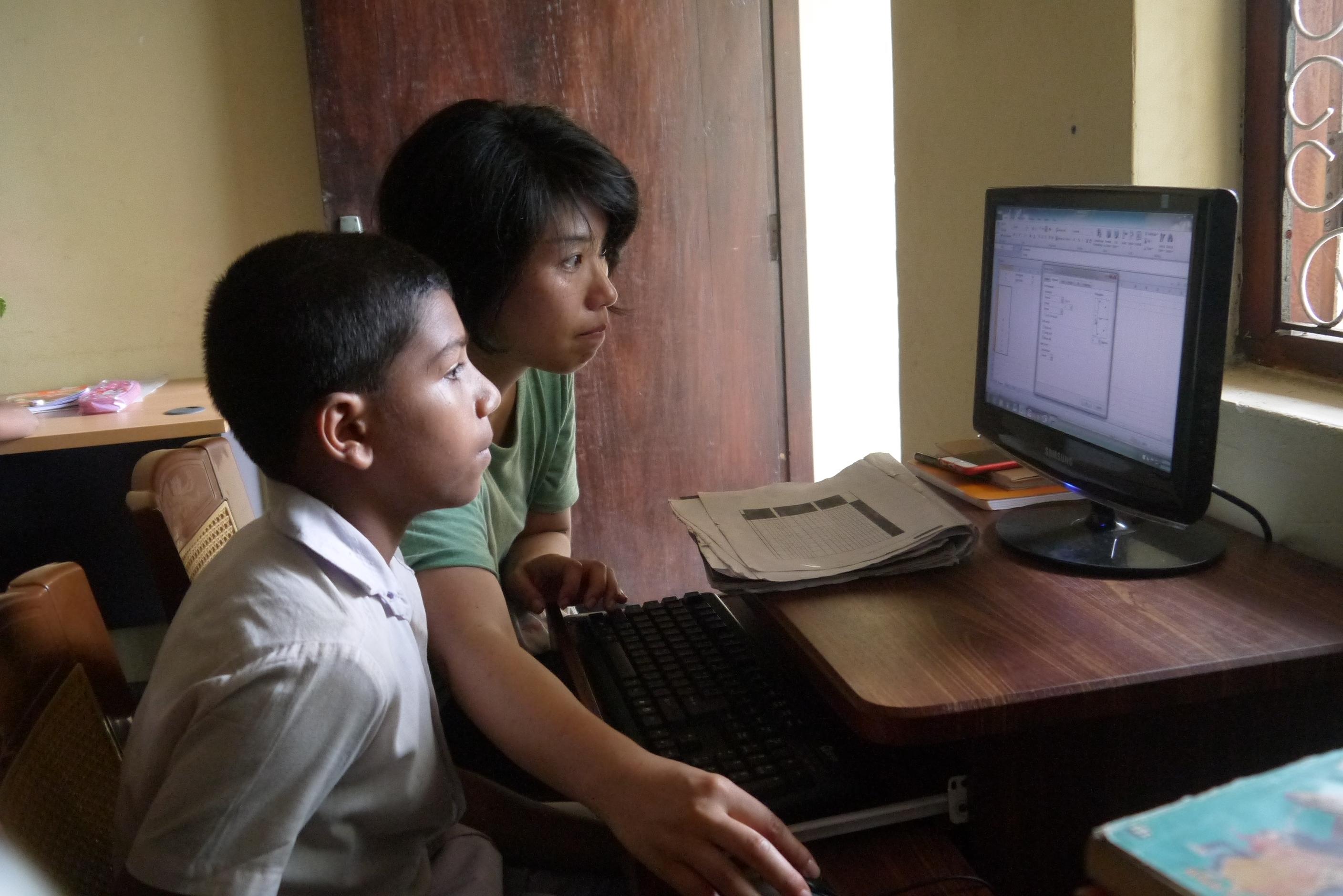 A Projects Abroad volunteer teaching IT in Sri Lanka while helping a student with his class exercise A volunteer helping her student on the computer during her IT teaching work experience in Sri Lanka